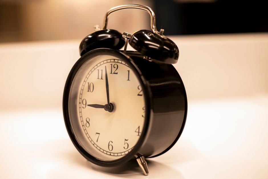 A classic black alarm clock with battery backup, showcasing its simplicity and functionality.