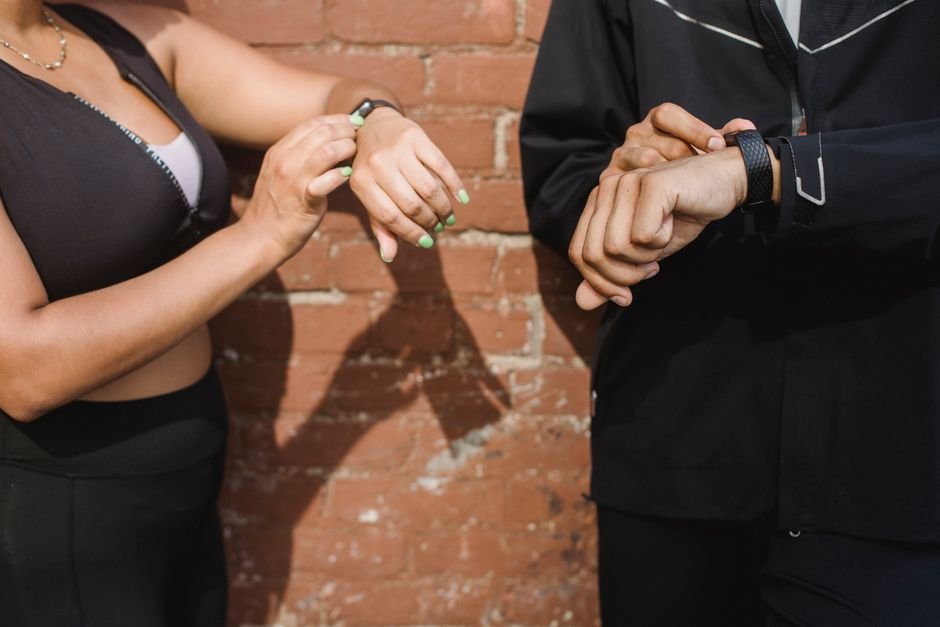 Two individuals wearing fitness trackers on their wrists, highlighting alarm features.