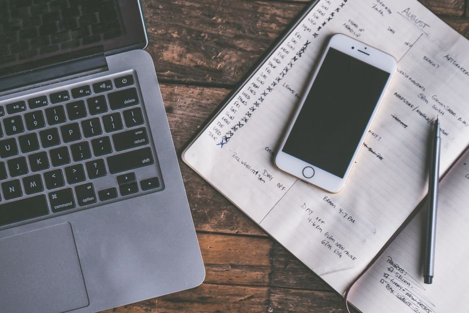 A laptop, smartphone, and paper planner showcasing digital and paper planning methods.