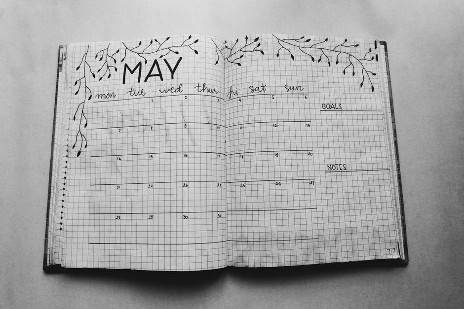 A hand-drawn monthly calendar for May in a notebook, illustrating the article on choosing a calendar.