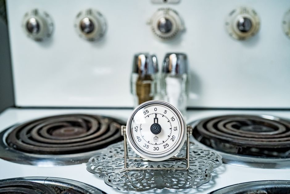 A visual timer sits on a stove, illustrating tools for adults with ADHD to manage time.