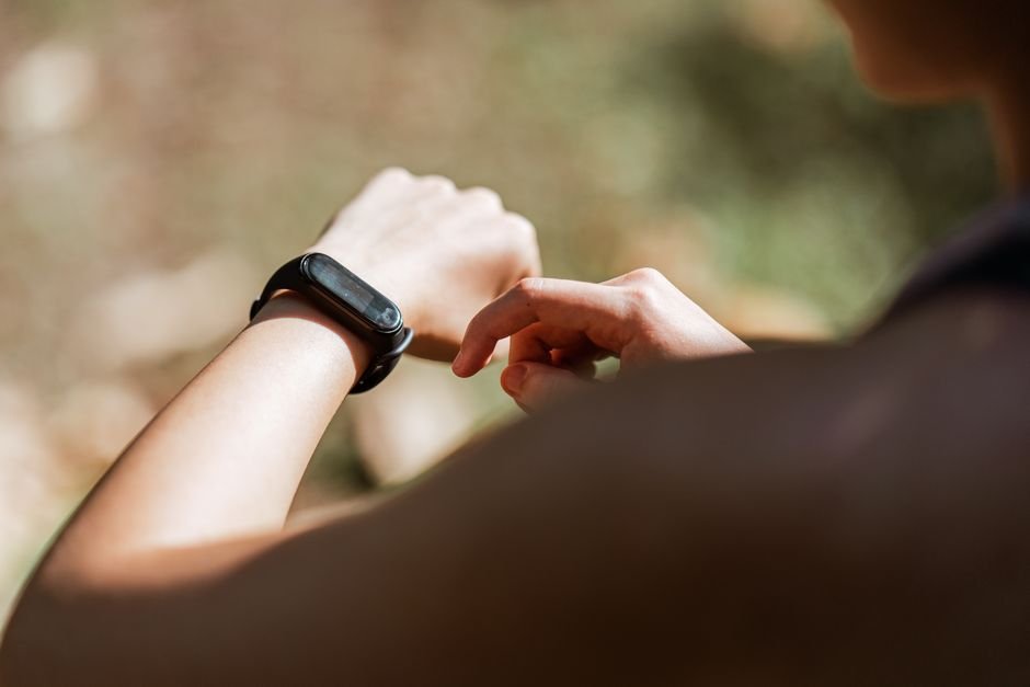 A person checking their fitness tracker on their wrist, related to charging tips.